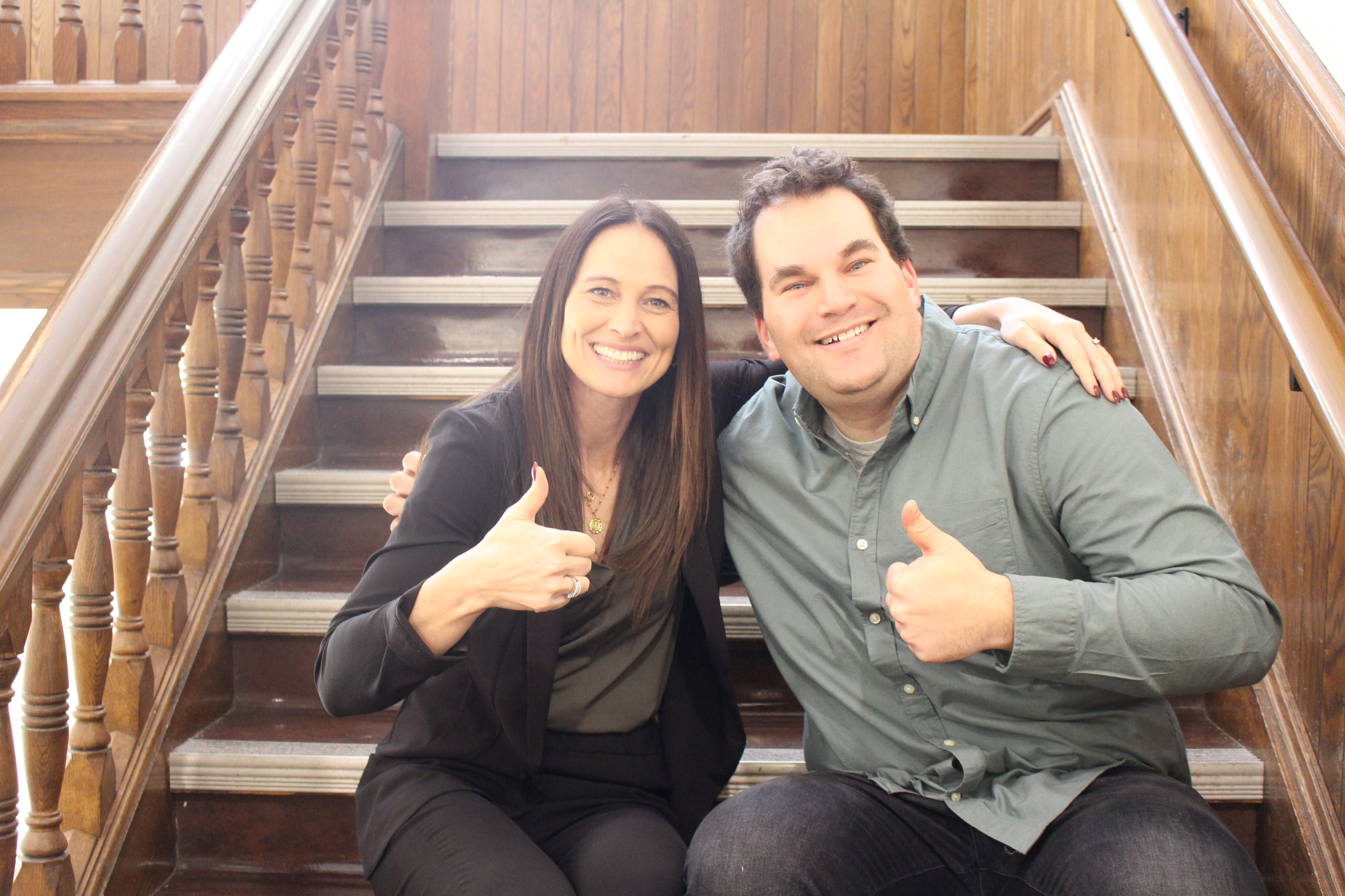 Collegiate staff members sitting on the stairs inside Wesley Hall